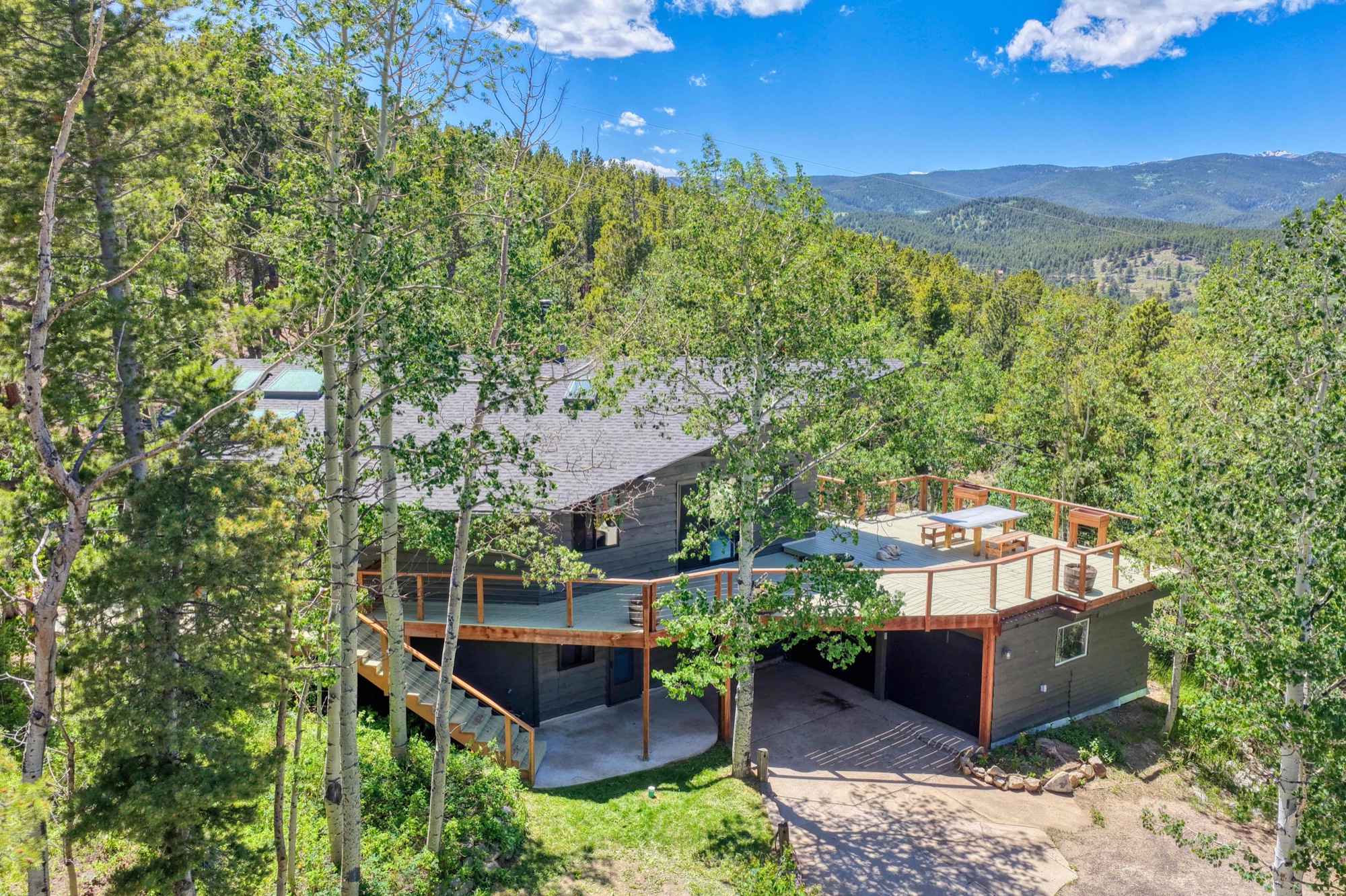 Aerial view of the home, deck, and mountains beyond